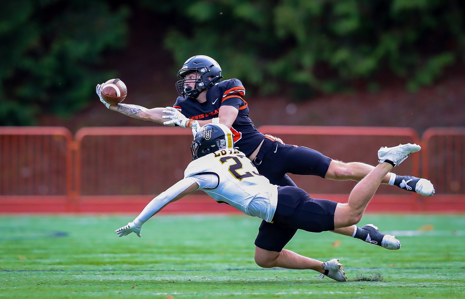 Receiver laying out for a one-handed catch over a defender