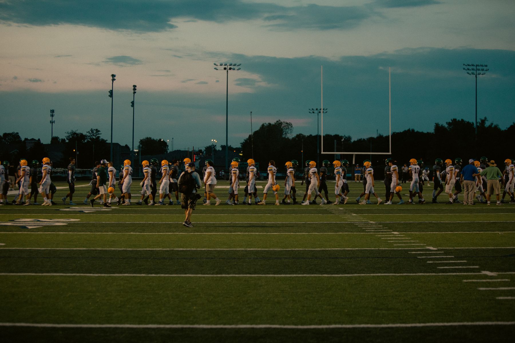 Two teams meeting at midfield at dusk