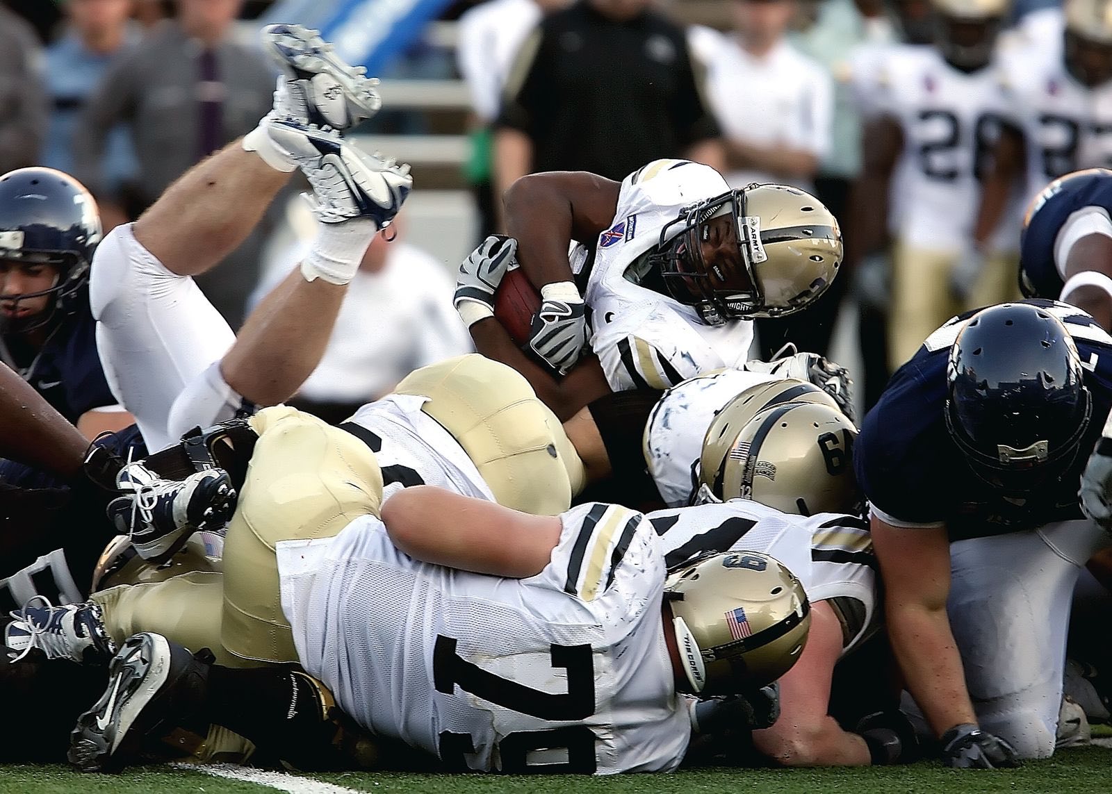 A goal line pile with the ball carrier fighting over the top